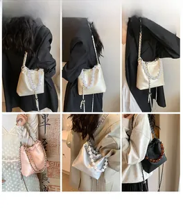 Detail of elegant gathered bucket bag with large beaded handle and metal chain strap in multiple colors