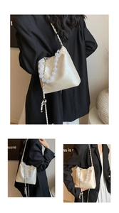 Detail of cream drawstring bag with beaded handle and silver chain strap on model