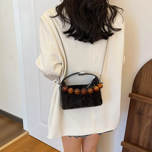 Minimalistische zwarte geplooide crossbodytas met amberkleurige kralen en ketting