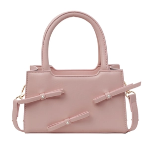 Pink faux leather tote bag with decorative pearl bows and detachable shoulder strap