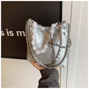 Detail of silver drawstring bag with beaded chain and metallic texture for women