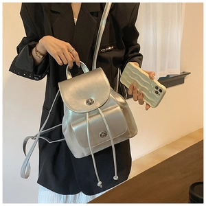 Detailed view of silver metallic PU leather backpack with drawstring and turn-lock closure