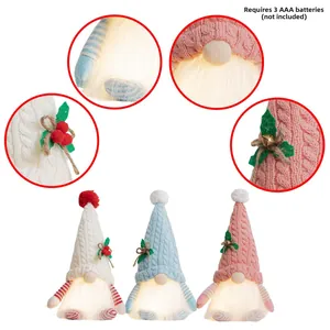 Detail view of glowing Christmas gnomes with knitted hats and battery compartment info
