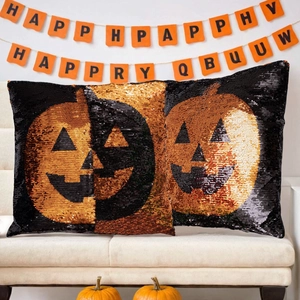 Cojines de calabaza de Halloween con lentejuelas reversibles sobre un sofá acogedor
