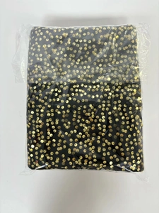 Detail of Christmas tree skirt with gold sequins in a clear plastic protective bag
