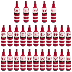 Detalle de fundas navideñas para botellas con letras tejidas y cinturón de Papá Noel