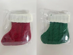 Detail of red and green cable knit Christmas stockings in transparent packaging bags