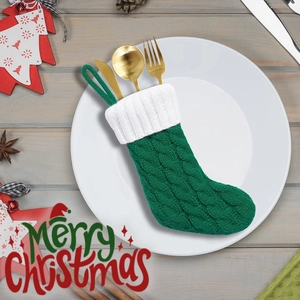 Nahaufnahme der grünen gestrickten Nikolaussocke als Besteckhalter für Weihnachten