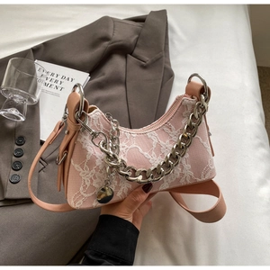 Detail of pink crescent bag with white lace overlay and silver metal chain strap