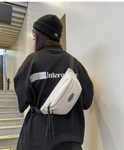 Détail du sac de poitrine blanc avec sangle réglable porté par un mannequin en extérieur