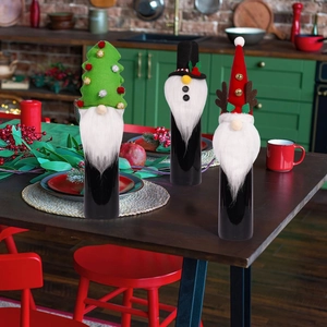 Three Christmas gnome wine bottle covers with reindeer antlers and festive forest hats