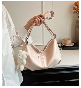 Detail of light pink tote bag with plush bear charm in a cozy home setting decor