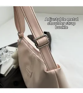 Close-up of adjustable silver metal buckle and pink shoulder strap on a fashion bag