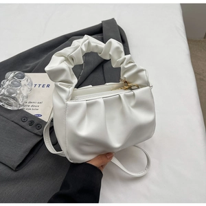 Detail of white pleated cloud bag showing soft PU texture and ruched handle design