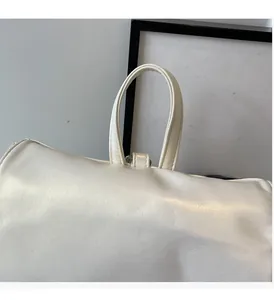 Détail de la poignée robuste du sac à dos blanc crème en similicuir style ballerine