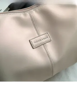 Detail shot of pink tote bag with textured synthetic leather and FASHION & BAGS label