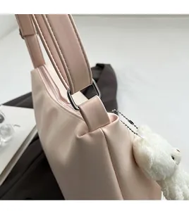 Detail of pink dumpling bag with smooth PU texture and silver square hardware connector