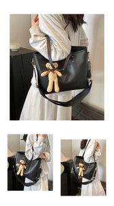 Detail der schwarzen Leder-Shopper mit breitem Textilriemen und gelbem Plüschbär-Anhänger