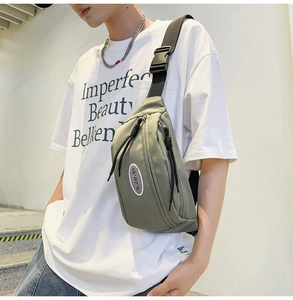 Détail du sac bandoulière en nylon vert olive avec logo blanc et boucle de sangle noire