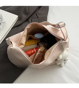 Detail view of the spacious inner compartment of the light pink tote bag with various items