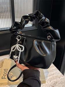 Minimalist black pleated cloud bag with pearl bow pendant and soft ruched top handle