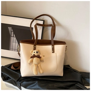 Detailansicht der großen Kontrast-Tote-Bag mit gestricktem Bärenanhänger und Schultergurt