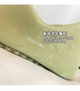Close-up of light green hobo bag with silver chain strap and CLEAR❤K brand logo