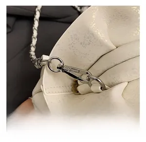 Detail of silver lobster clasp and leather woven metal chain on the white cloud bag