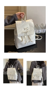 Détail d'un mini sac à dos blanc en PU avec nœud style ballerine et bretelles chaîne