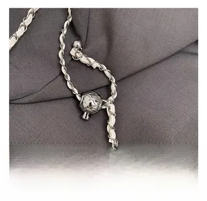Close-up of adjustable silver chain strap with quilted metal ball buckle on bag