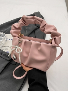 Pink ruched cloud bag with pearl bow pendant and crossbody strap for elegant women