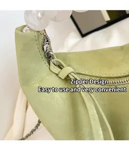 Detail view of smooth metal zipper and textured light green leather on hand-beaded bag
