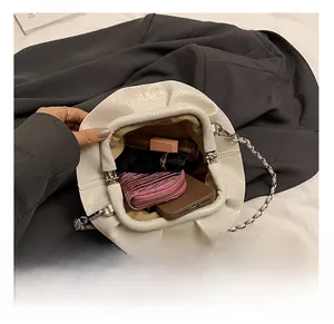Internal capacity of the white pleated cloud bag showing space for phone and makeup items