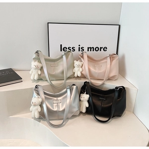 Minimalist tote bags in four colors with cute plush bear charms on display stand