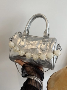 Bolso Boston plisado plateado con cuentas de mármol y correa de cadena mostrado por modelo