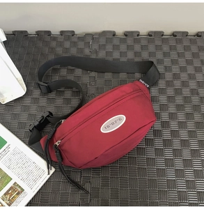 Détail du sac de poitrine en nylon bordeaux montrant la sangle ajustable et les boucles