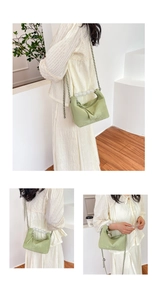 Detail of light green beaded handle handbag with metal chain and textured finish
