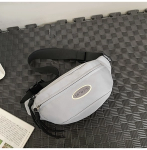 Détail du sac bandoulière gris montrant le nylon résistant et la boucle de sangle