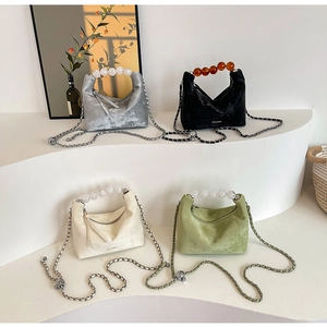 Showcase of beaded handle handbags in silver, black, cream and green velvet finishes