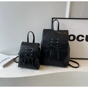 Détail de deux tailles de sacs à dos noirs balletcore avec nœuds et œillets