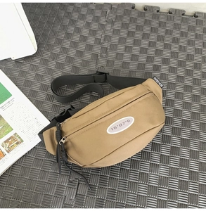 Détail d'un sac bandoulière kaki avec imprimé et sangle noire réglable en nylon robuste