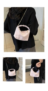 Macro detail of pleated cloud handle and gold chain on light pink crossbody bag