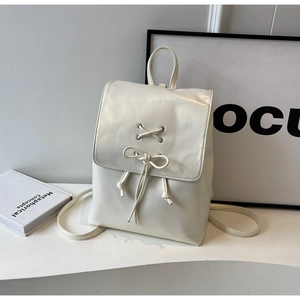 Vue détaillée du sac à dos crème style ballet avec nœuds et design de laçage