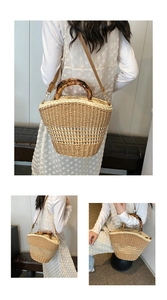 Detail of woven straw bucket bag with bamboo handles and removable leather shoulder strap