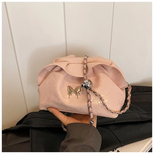 Detailed shot of pink pleated cloud bag featuring metal bow buckle and chain strap