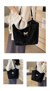 Detail of black bow tote bag with textured fabric and silver metallic butterfly buckle