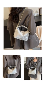 Detail of silver metallic textured handbag with pleated handle and golden chain strap