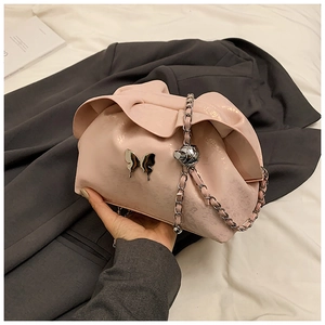 Detail of pink ruched cloud bag featuring silver butterfly buckle and chain strap