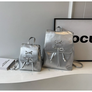 Comparaison de taille des sacs à dos argentés métallisés avec nœuds décoratifs