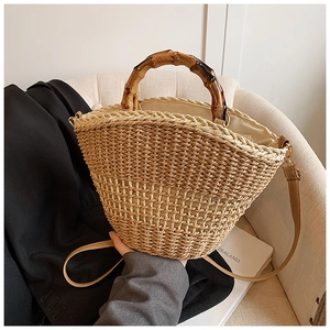 Detailed texture of hand-woven straw bucket bag with vintage bamboo handle and leather strap